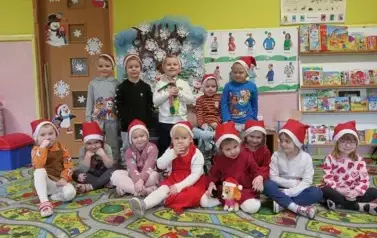 zdjęcie dzieci pod tablicą w mikołjkowych czapkach
