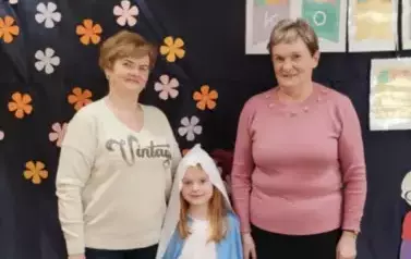 Babcie i wnuczka pozują do zdjęcia