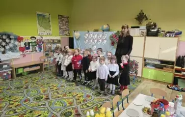 dzieci z Panią Agnieszką na tle tablicy Dzień Babci i Dziadka