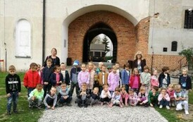 dzieci pozują przed bramą