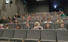 Dzieci siedzą w kinie i czekają na seans