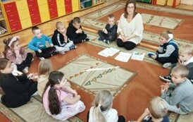 Dzieci i pani Kasia siedzą na dywanie