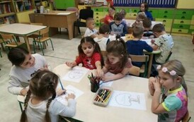 Dzieci kolorują przy stolikach