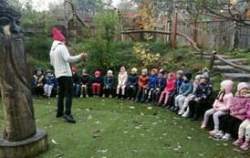Dzieci siedzą i słuchają prowadzącej