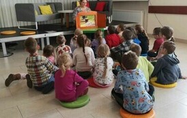 Dzieci oglądają teatrzyk Kamishibai