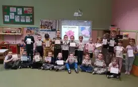 Dzieci pozują do zdjęcia z rysunkami