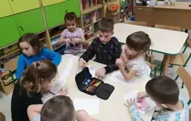 Dzieci kolorują przy stolikach