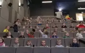 Dzieci siedzą w kinie na fotelach