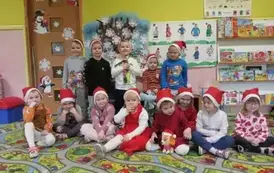 zdjęcie dzieci pod tablicą w mikołjkowych czapkach
