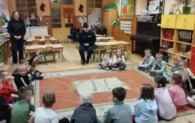 Dzieci siedzą w kole na dywanie